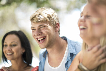 Four young and mid adult friends laughing at beach party - ISF05679