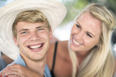 Junges Paar lacht zusammen auf einer Strandparty, lizenzfreies Stockfoto