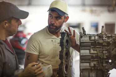 Two men repairing outboard motor in boat repair workshop - ISF05769