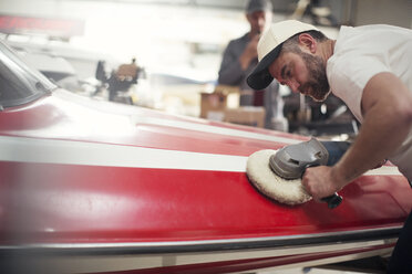 Man polishing boat in repair workshop - ISF05774