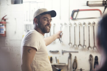 Man selecting wrench in boat repair workshop - ISF05783