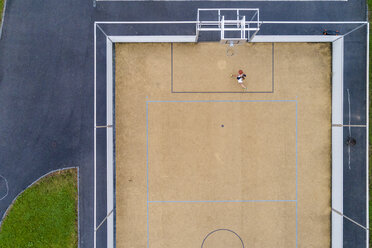 Junge Frau spielt Basketball, Luftaufnahme - STSF01584