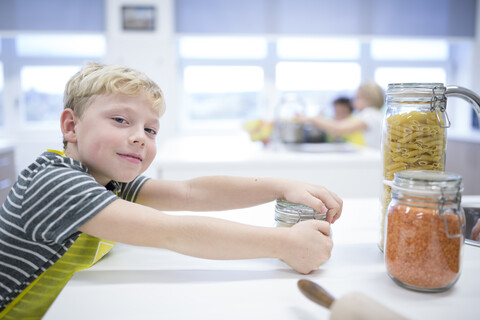 A happy young student learns culinary skills in a cooking class with a big smile on his face. stock photo