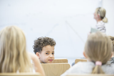 Eine Gruppe von Schülern und ihre Lehrerin posieren für ein Klassenfoto in einer Schule. - WESTF24115