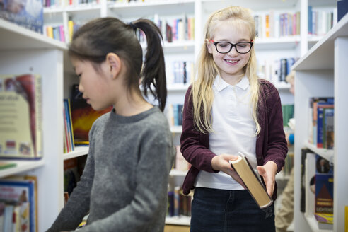 Zwei Schüler lernen in der Schulbibliothek, umgeben von Büchern und Materialien - WESTF24138