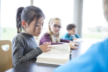 Eine fleißige Schülerin vertieft in ihr Buch während einer Pause in der gemütlichen Pausenhalle der Schule - WESTF24140