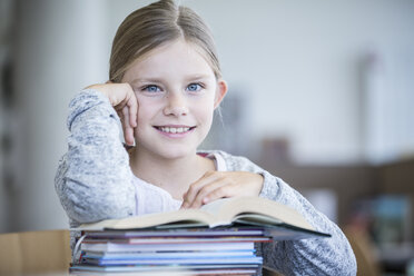 A cheerful schoolgirl poses with her books, radiating positivity and eagerness to learn. - WESTF24146