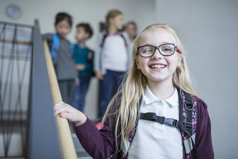 Eine Gruppe fröhlicher Schulmädchen verabschiedet sich nach einem Schultag auf der Treppe., lizenzfreies Stockfoto