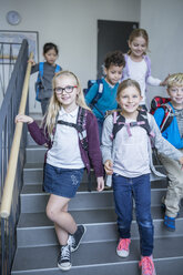 Fröhliche Schülerinnen und Schüler verabschieden sich auf der Schultreppe und freuen sich auf ihre Abenteuer am Nachmittag - WESTF24169