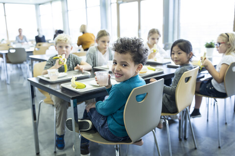 Schüler genießen ihr Mittagessen in der Schulcafeteria, lizenzfreies Stockfoto