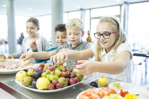 Students waiting in line at the school cafeteria counter to purchase their meals. stock photo