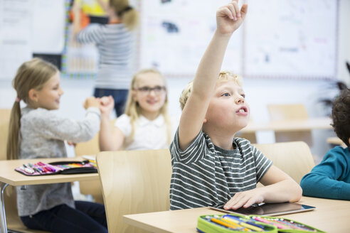 Ein junger Schüler beteiligt sich aktiv am Unterricht und nutzt ein Tablet, um seine Lernerfahrung zu verbessern - WESTF24209