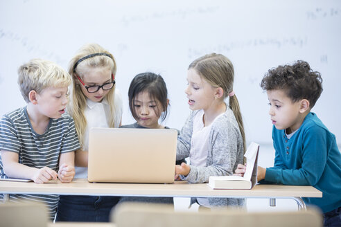 Schüler arbeiten gemeinsam an einem Laptop-Projekt im Klassenzimmer - WESTF24217