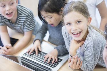 Eifrige Schülerinnen und Schüler, die durch den Einsatz von Technologie in einem Klassenzimmer interaktiv lernen. - WESTF24218