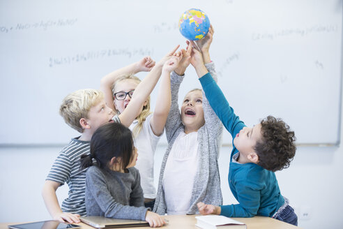 Begeisterte Schülerinnen und Schüler halten während einer Unterrichtsstunde gemeinsam die Welt in ihren Händen - WESTF24220