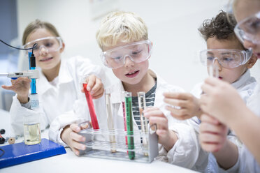 Schüler führen in einem naturwissenschaftlichen Klassenzimmer Experimente mit Flüssigkeiten in Reagenzgläsern durch - WESTF24240