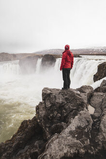 Iceland, man standing at Godafoss waterfall - KKAF01034