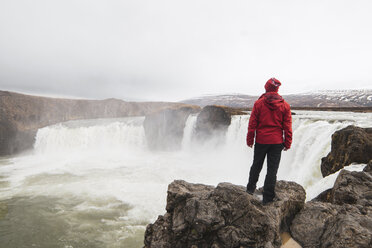 Iceland, man standing at Godafoss waterfall - KKAF01035