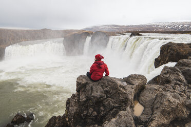 Island, Mann sitzt am Godafoss-Wasserfall - KKAF01036