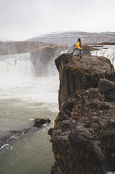 Island, Frau steht am Godafoss-Wasserfall - KKAF01040