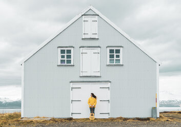 Island, Frau mit Gitarre vor einsamem Haus stehend - KKAF01047