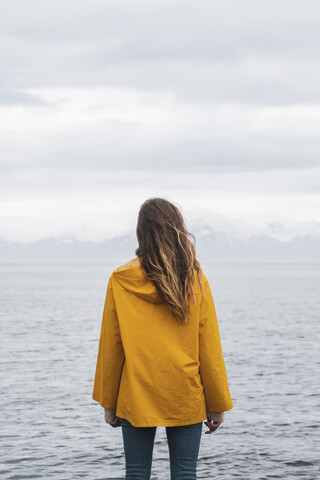 Iceland, woman standing at the sea stock photo