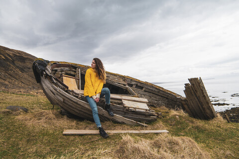 Island, Frau in Bootswrack an der Küste, lizenzfreies Stockfoto