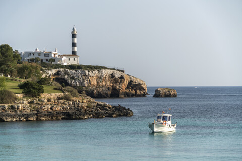 Spanien, Balearen, Mallorca, Portocolom, Leuchtturm und Fischerboot, lizenzfreies Stockfoto