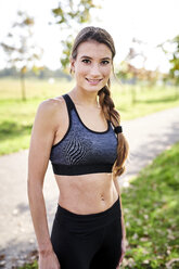 Portrait of smiling sportive young woman - MMIF00098