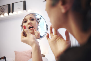 Spiegelbild einer Frau, die Lippenstift aufträgt - ISF05811