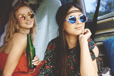 Zwei junge Boho-Frauen mit Sonnenbrillen in einem Wohnmobil - ISF05812
