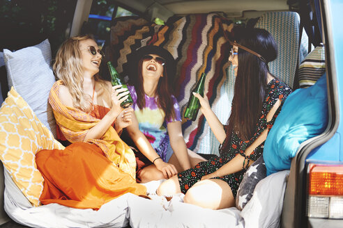 Drei junge Boho-Frauen lachen im Freizeitfahrzeug - ISF05815