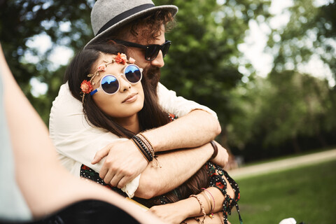 Romantisches junges Boho-Paar, das sich auf einem Festival umarmt, lizenzfreies Stockfoto