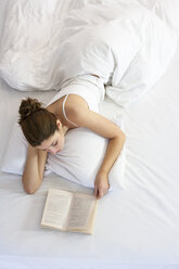 Frau liegt auf dem Bett und liest ein Buch - ISF05906