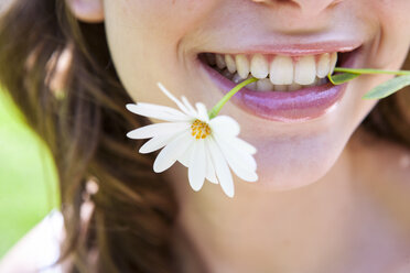 Nahaufnahme einer Frau mit Gänseblümchen zwischen den Zähnen - ISF05927