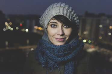 Porträt einer Frau mit Strickmütze in der Stadt bei Nacht - ISF05950