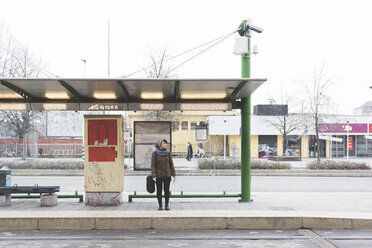 Female backpacker standing at city bus station - ISF05951