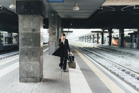 Geschäftsfrau mit Mobiltelefon im Bahnhof, Mailand, Italien, lizenzfreies Stockfoto