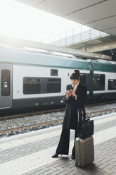 Geschäftsfrau mit Mobiltelefon im Bahnhof, Mailand, Italien - ISF05959