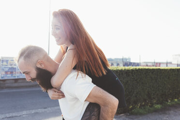 Man giving red haired woman piggyback - ISF05982