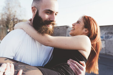 Bearded man carrying smiling woman in arms - ISF05983