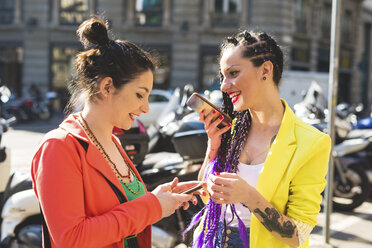 Frauen bei einer Städtereise mit Mobiltelefon, Mailand, Italien - ISF05992