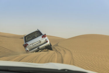 Off road vehicle driving over steep desert dunes, Dubai, United Arab Emirates - ISF06015