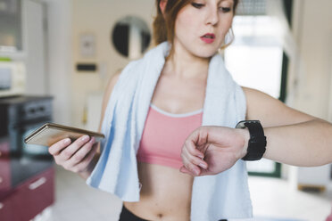 Junge Frau beim Training, Blick auf die Smartwatch - ISF06037