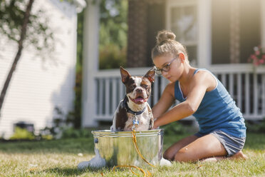 Mädchen wäscht Hund in Eimer - ISF06051