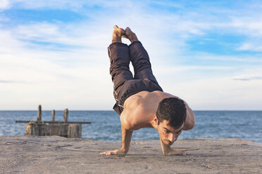 Junger Mann im Freien, in Yoga-Position, auf Händen balancierend - ISF06069