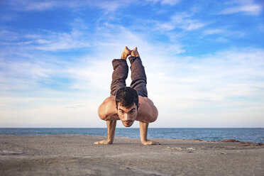 Junger Mann im Freien, in Yoga-Position, auf Händen balancierend - ISF06070