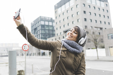 Mid adult woman taking smartphone selfie in city - ISF06079