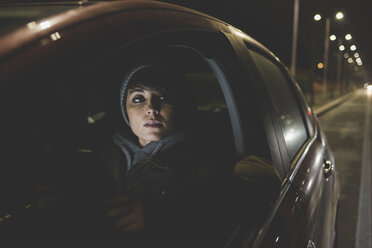Frau schaut aus dem Autofenster am nächtlichen Straßenrand der Stadt - ISF06088