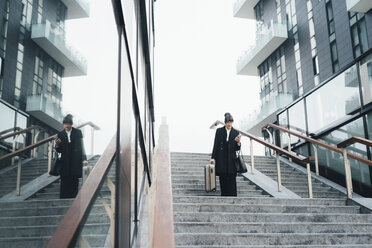 Businesswoman using mobile and carrying trolley luggage, Milan, Italy - ISF06106